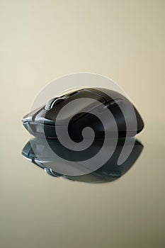 Sleek black computer mouse on a reflective surface