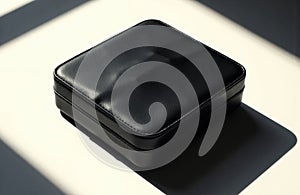 A sleek black leather case with a shiny surface placed on a white background