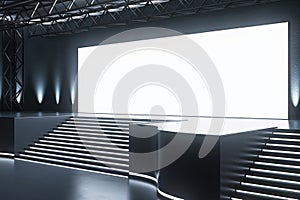 Sleek conference hall with spotlighted stage and audience seating. Corporate event space.