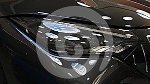 Sleek elegant LED headlight on modern Mercedes Benz AMG grand tourer roadster car with reflection of interior lights.