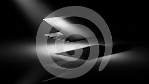 Sleek Laptop in Dramatic Spotlight on Reflective Surface