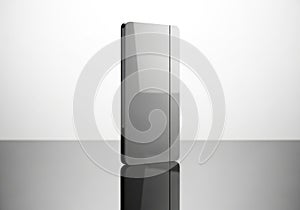 Sleek silver rectangular object standing upright on a reflective surface