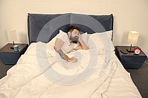 Sleep disorders concept. Man bearded hipster having problems with sleep. Guy lying in bed try to relax and fall asleep