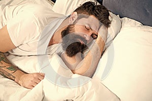 Sleep disorders concept. Man bearded hipster having problems with sleep. Guy lying in bed try to relax and fall asleep