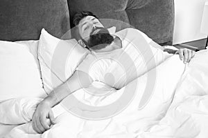 Sleep disorders concept. Man bearded hipster having problems with sleep. Guy lying in bed try to relax and fall asleep