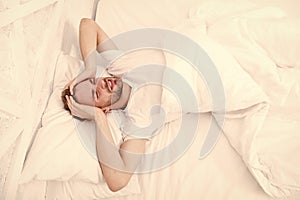 Sleep problems can lead to headaches in morning. Handsome man relaxing in bed. Snoring can increase risk headaches