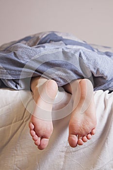 Sleep and relax concept. Beautiful groomed bare feet of cute little child girl