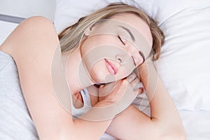 Sleep. Young woman sleeping in bed, portrait of beautiful female resting on comfortable bed with pillows in white bedding