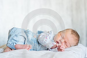 Sleeper newborn baby in a denim jumpsuit