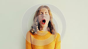 Sleepiness. Young tired woman yawns opens her mouth wide photo