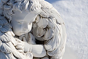 Sleeping angel statue.Angel guardian sleeping in white snow background