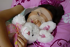 Sleeping Asian Girl Holding Her Toy Rabbit.