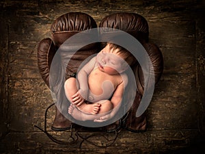 Sleeping baby in boxing gloves