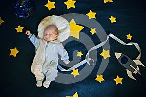 Sleeping baby boy astronaut on a background of the sky