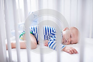 Sleeping baby boy in white crib