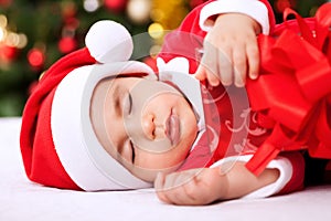 Sleeping baby child santa holding gifts