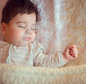 Sleeping baby covered with knitted blanket