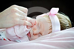 Sleeping baby holding parent hand newborn close up
