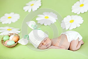 Sleeping baby infant as rabbit and Easter eggs