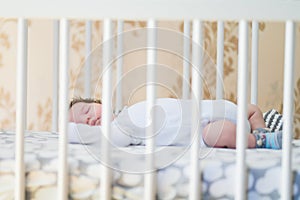 Sleeping baby. Peaceful baby lying on a bed while sleeping in a bright room