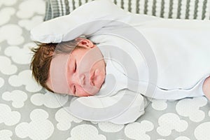 Sleeping baby. Peaceful baby lying on a bed while sleeping in a bright room