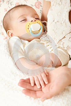 Sleeping baby portrait in mother hand, happy maternity and childhood concept, focus on face