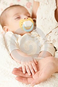 Sleeping baby portrait in mother hand, happy maternity and childhood concept, focus on hand