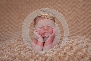 Sleeping baby propped on elbows photo