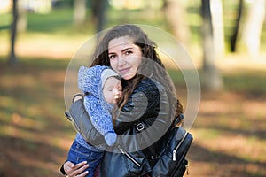 Sleeping baby on a walk. Sleeping little girl, boy on his mother s shoulder in the autumn park