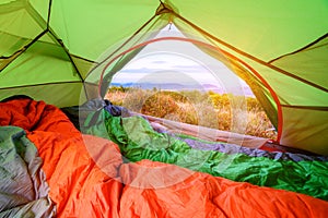 Sleeping bag inside a tent looking out with view through the back door