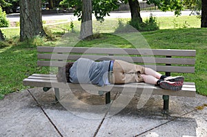 Sleeping on a bench in a public