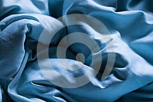 Sleeping blue bed sheet covered in morning or evening gentle sun