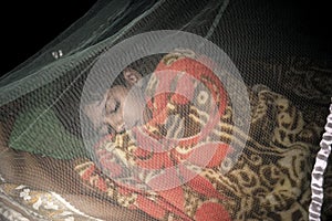 A sleeping boy inside a mosquito net,the safest and easiest way to prevent mosquitoes photo