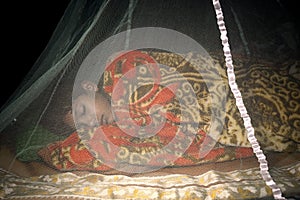 A sleeping boy inside a mosquito net,the safest and easiest way to prevent mosquitoes