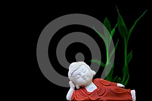 Sleeping buddha figurine decorated with lucky green plant