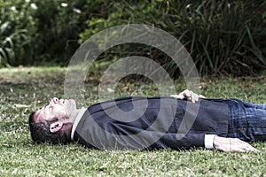 Sleeping businessman lying on grass, textured effect