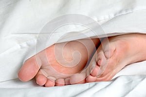 A sleeping childs feet in bedding