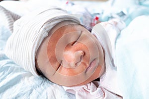 The Sleeping cute New Born Baby with hat infant on the bed