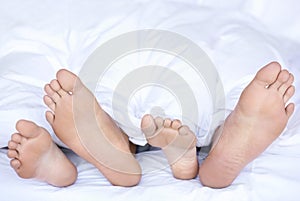 Sleeping, feet and couple in bed with peace, safety and protection, rest or calm bonding at home. Sleep, love and people