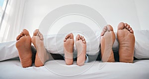 Sleeping, feet and family in a bed with love, relax and resting in comfort in their home together. Barefoot, care and