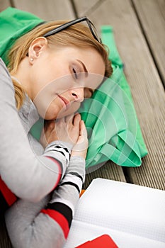 Sleeping girl with books outdoors