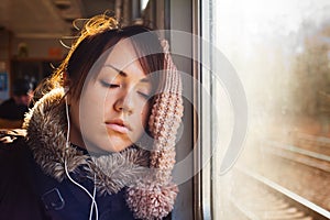 Sleeping girl with headphones in train