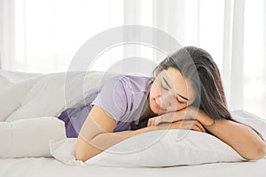 Sleeping girl lying on the white bed on her comfy pillow in the morning