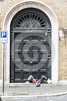 A sleeping homeless man lay down on the old door in Rome