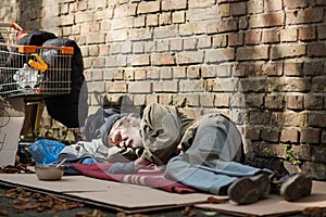 Sleeping homeless man lying on cardboard.