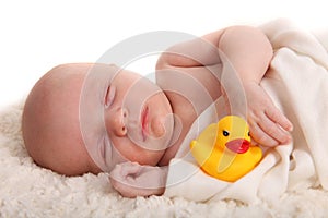 Sleeping Infant With a Rubber Duckie on White