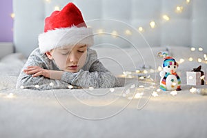 Sleeping little boy child in Santa Claus hat