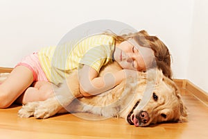 Sleeping little girl lying on her Golden Retriever