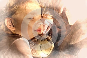 Sleeping little girl in pjamas with teddy bear lie down on bed while sun shine through the window, glare and toned effect