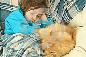 Sleeping little girl with red cat